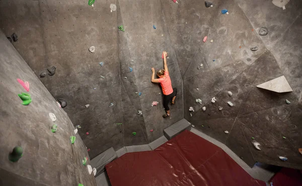 Jovem mulher se exercitando no ginásio de escalada indoor — Fotografia de Stock