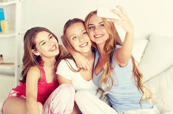 Chicas adolescentes con teléfono inteligente tomando selfie en casa —  Fotos de Stock