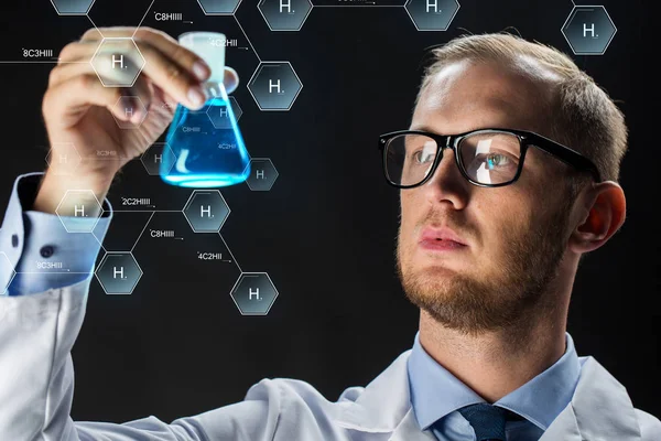 Jovem cientista segurando frasco de ensaio com produto químico — Fotografia de Stock