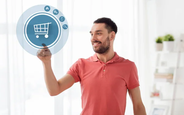 Hombre con la proyección del icono del carrito de compras en casa —  Fotos de Stock