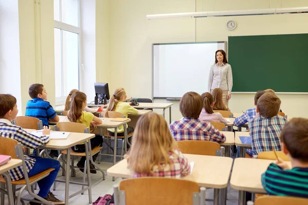 Grupp av skolbarnen med lärare i klassrummet — Stockfoto