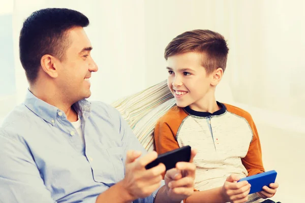 Glücklicher Vater und Sohn mit Smartphones zu Hause — Stockfoto