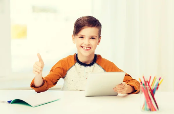 Щасливий хлопчик з планшетним ПК показує великі пальці вдома — стокове фото
