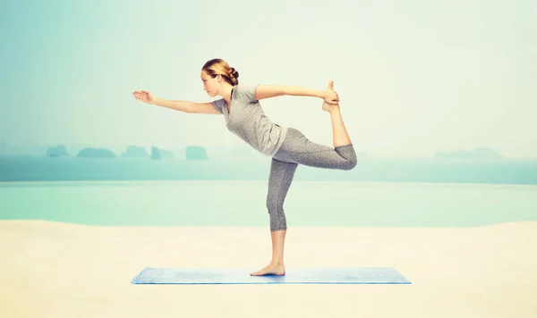 Vrouw maken yoga in heer van de dans pose op mat — Stockfoto