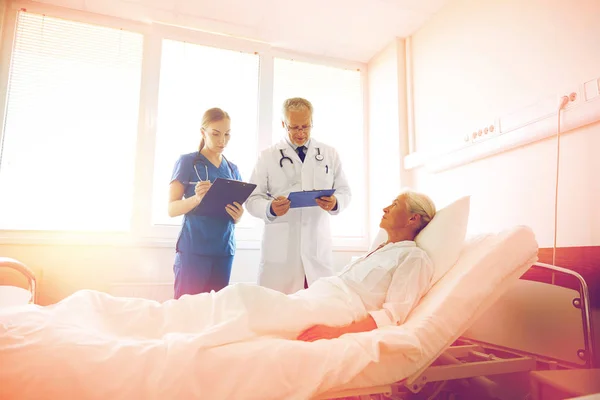 Arzt und Krankenschwester besuchen Seniorin im Krankenhaus — Stockfoto