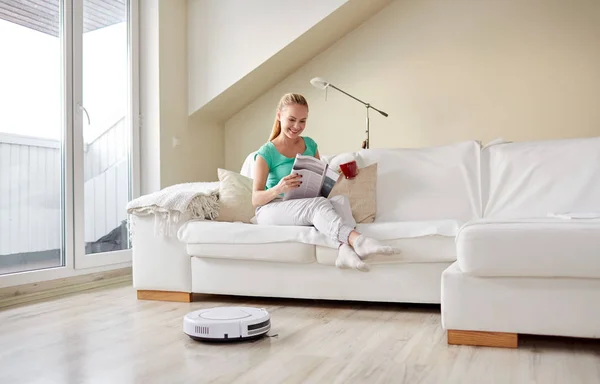 Mujer feliz y robot aspiradora en casa —  Fotos de Stock