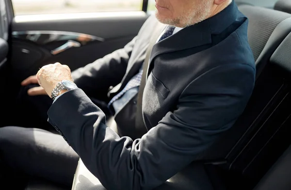 Старший бизнесмен вождение на заднем сиденье автомобиля — стоковое фото