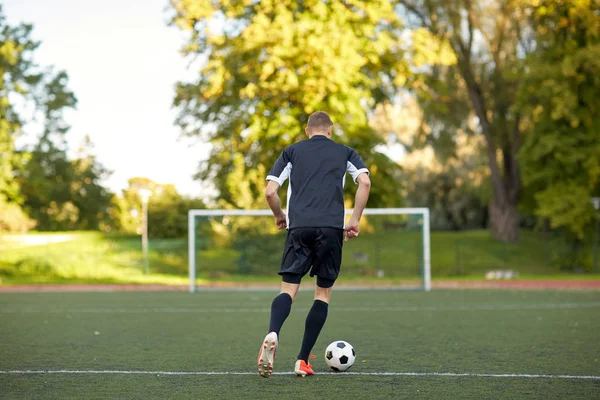 Giocatore di calcio che gioca con la palla sul campo di calcio — Foto Stock