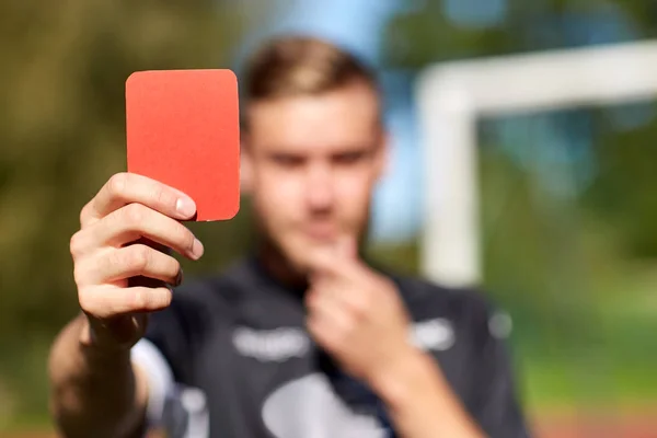 Mãos árbitro com cartão vermelho no campo de futebol — Fotografia de Stock