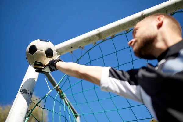 Goalkeeper with ball at football goal on field — Stock Photo, Image