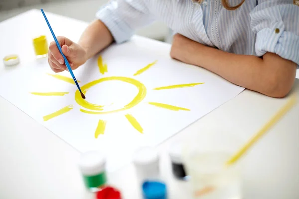 Ragazza con pennello disegno sole su carta — Foto Stock