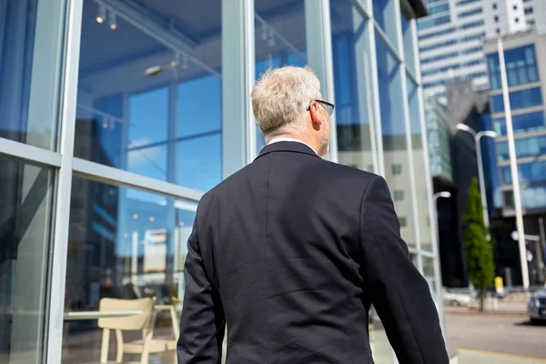 Senior zakenman wandelen langs stad straat — Stockfoto