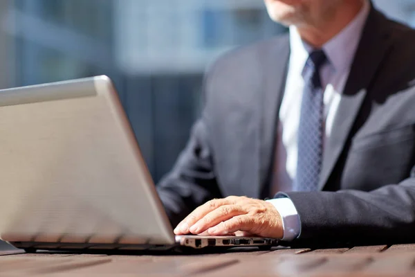 Старший бизнесмен с ноутбуком на открытом воздухе кафе — стоковое фото