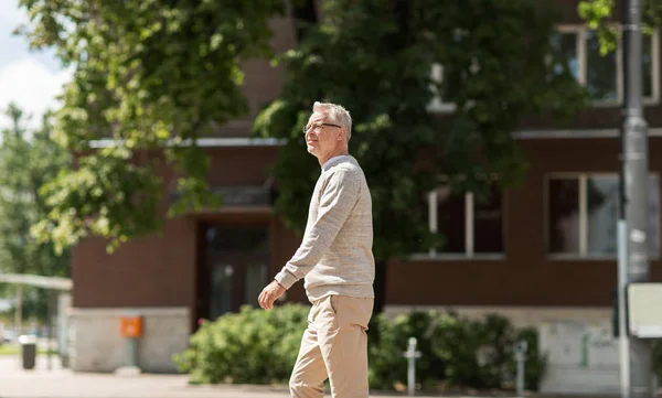 Hombre mayor caminando por la calle de la ciudad de verano — Foto de Stock