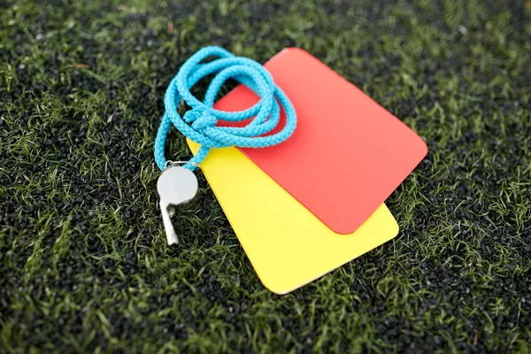 Whistle and caution cards on football field — Stock Photo, Image