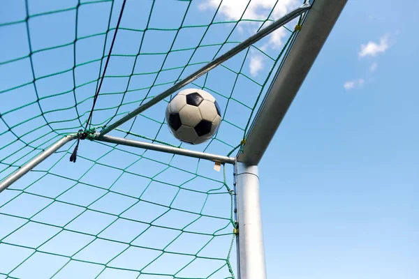 Bola de futebol voando em futebol gol net sobre o céu — Fotografia de Stock
