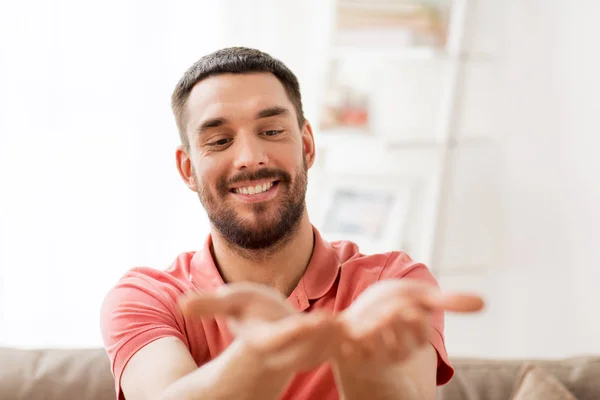 Homem feliz segurando algo imaginário em casa — Fotografia de Stock