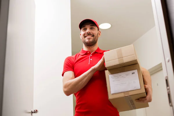 Repartidor con cajas de paquetes a la puerta del cliente — Foto de Stock