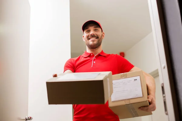 Repartidor con cajas de paquetes a la puerta del cliente — Foto de Stock