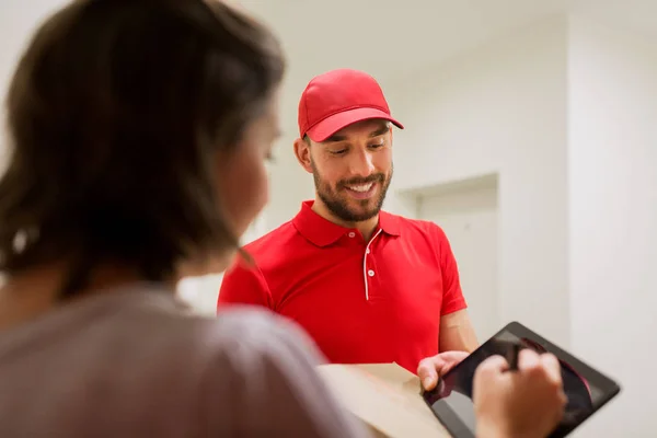 Hombre de entrega con caja y tableta pc al cliente — Foto de Stock