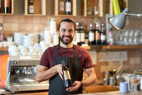 Homme heureux ou serveur avec bouteille de vin rouge au bar — Photo