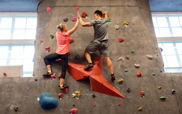 Hombre y mujer haciendo ejercicio en el gimnasio de escalada interior — Foto de Stock