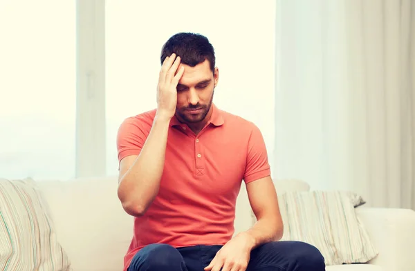 Unhappy man suffering from headache at home — Stock Photo, Image