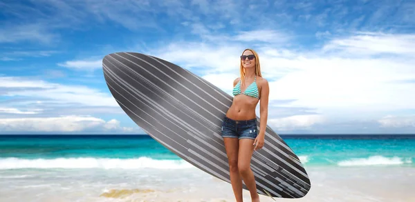 Uśmiechnięta młoda kobieta z deską surfingową na plaży — Zdjęcie stockowe