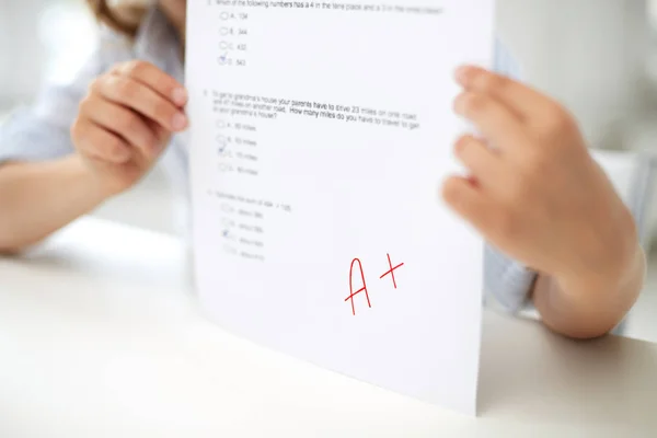 Chica con papel de prueba en la escuela — Foto de Stock