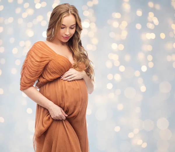 Mulher grávida feliz tocando sua barriga grande — Fotografia de Stock