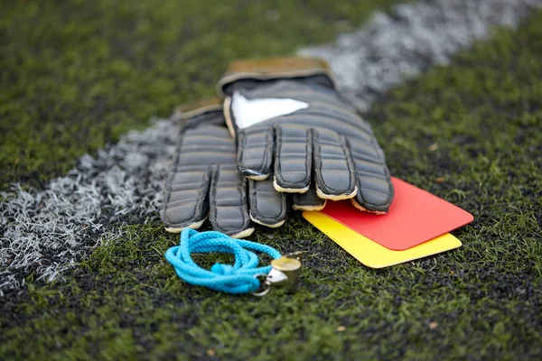 Gloves, whistle and caution cards on soccer field — Stock Photo, Image