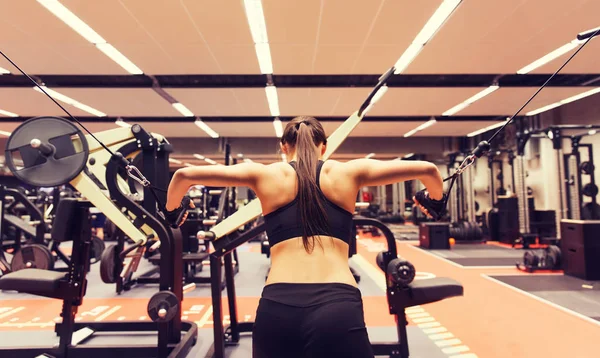 可弯曲的肌肉在健身房中电缆机上的女人 — 图库照片