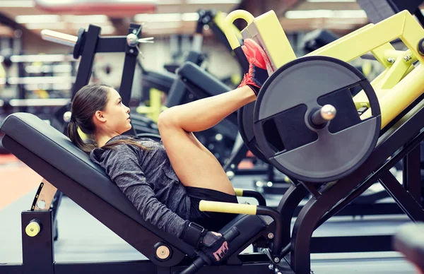 Frau lässt Muskeln an Beinpressmaschine im Fitnessstudio spielen — Stockfoto