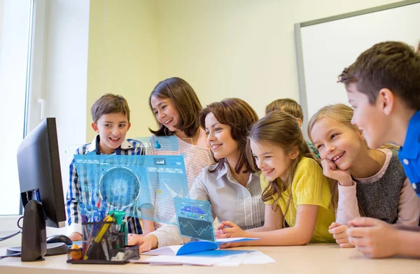 Groep van jonge geitjes met leraar en computer op school — Stockfoto