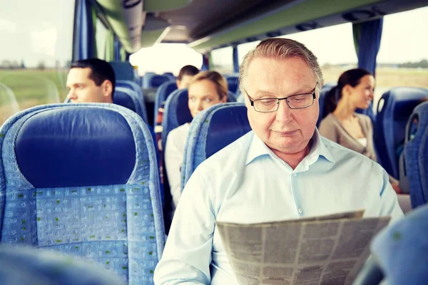 Glücklicher Senior liest Zeitung im Reisebus — Stockfoto