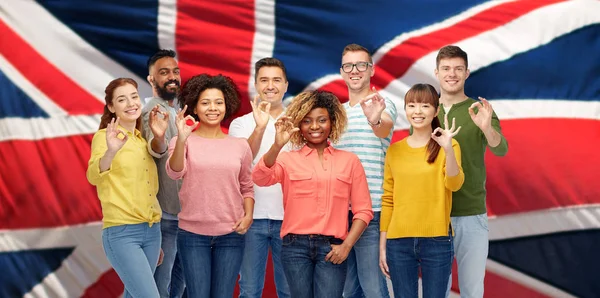 Pessoas internacionais mostrando ok sobre bandeira britânica — Fotografia de Stock