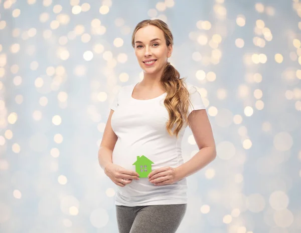 Felice donna incinta con casa verde — Foto Stock