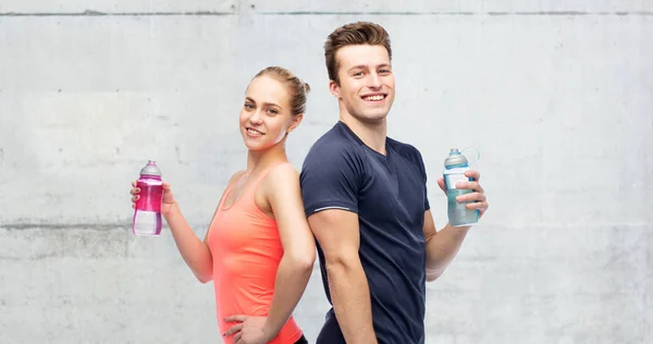 Sportif erkek ve kadın su şişeleri ile — Stok fotoğraf