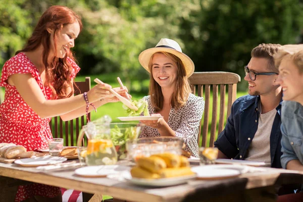 Счастливые друзья, ужинающие на вечеринке в летнем саду — стоковое фото