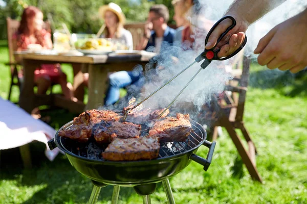 Uomo che cucina carne alla griglia alla festa estiva — Foto Stock