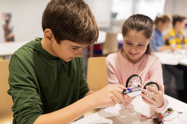 Glückliche Kinder bauen Roboter in der Robotikschule — Stockfoto