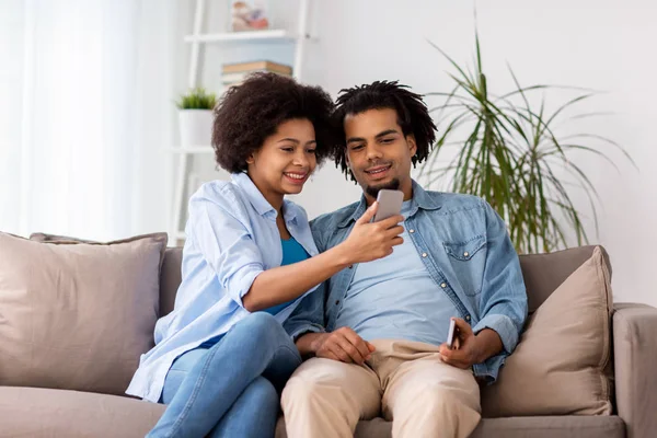 Glückliches Paar mit Smartphone zu Hause — Stockfoto