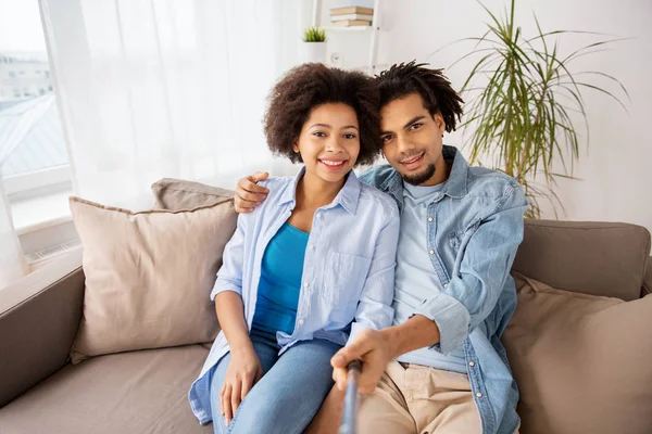 Feliz pareja con selfie palo en casa — Foto de Stock