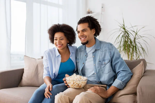 Χαμογελώντας ζευγάρι με ποπ κορν βλέποντας τηλεόραση στο σπίτι — Φωτογραφία Αρχείου