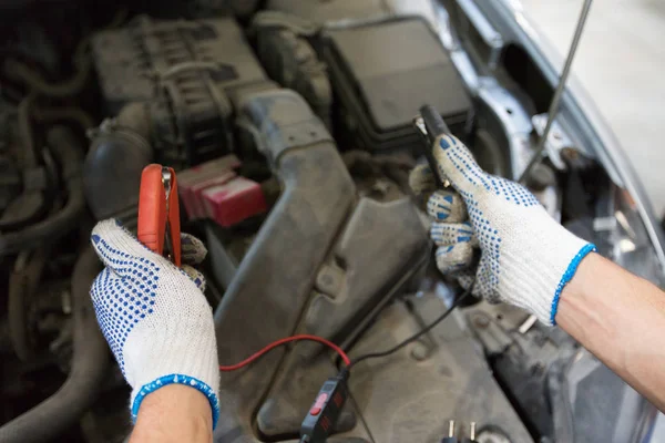 Auto mechanik człowiek z korki ładowania baterii — Zdjęcie stockowe