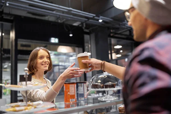 Vendedor dando taza de café a la mujer cliente en la cafetería —  Fotos de Stock