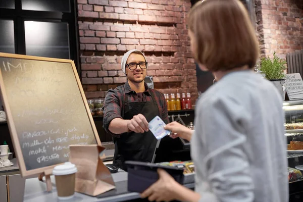 Glad barman och kvinnan betala pengar på café — Stockfoto