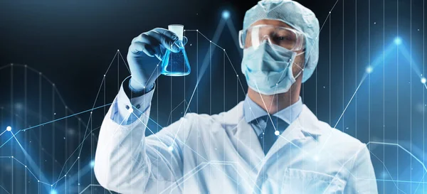 Учёный в маске держит фляжку с химикатами — стоковое фото