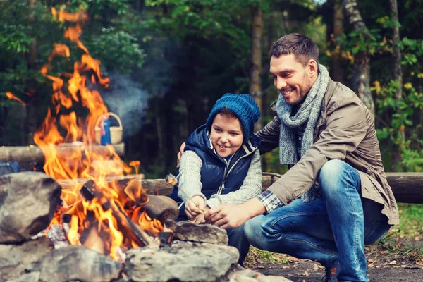 Père et fils rôtissant guimauve sur feu de camp — Photo