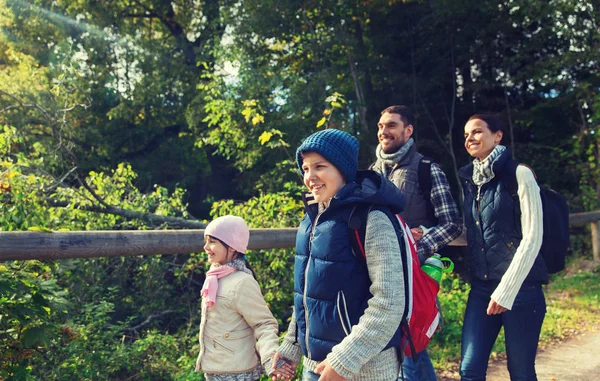 Familia feliz con mochilas senderismo en el bosque — Foto de Stock